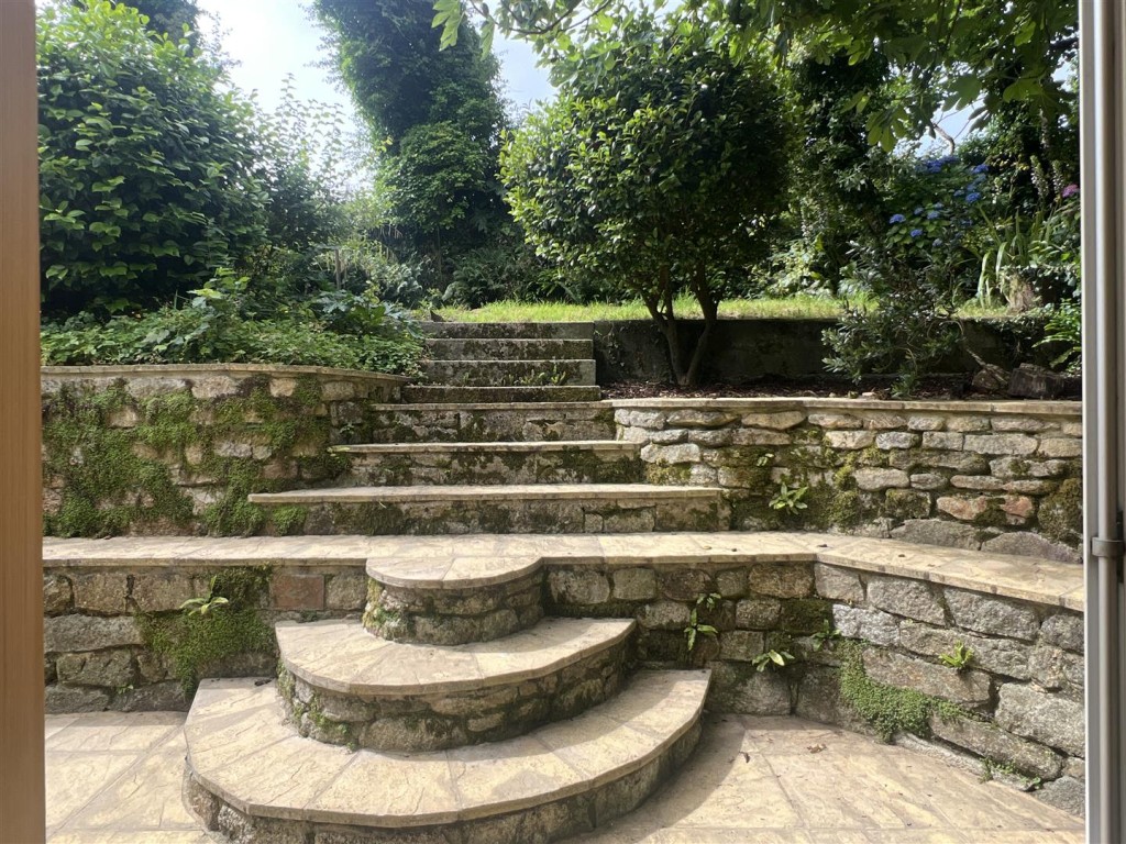 Lot: 138 - WELL PRESENTED DETACHED TWO-BEDROOM CHARACTERFUL COTTAGE WITH GARDENS AND PARKING - Tiered patio and steps up to lawned garden